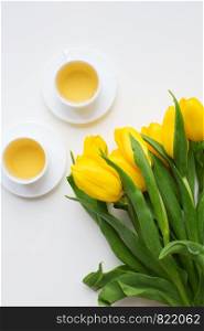 beautiful yellow tulips, two cups of green tea, spring. beautiful yellow tulips
