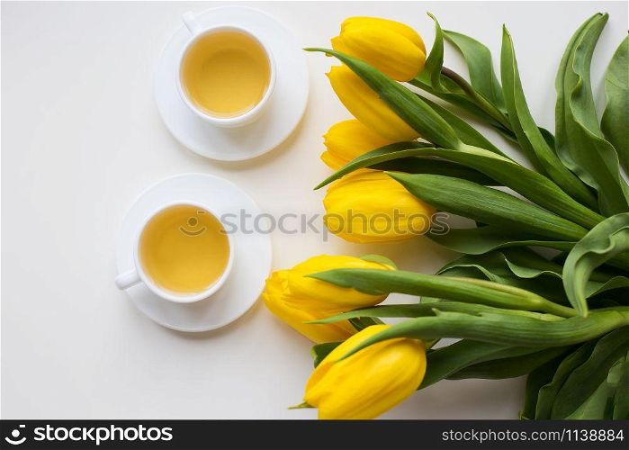 beautiful yellow tulips, two cups of green tea, spring. valentine card. beautiful yellow tulips