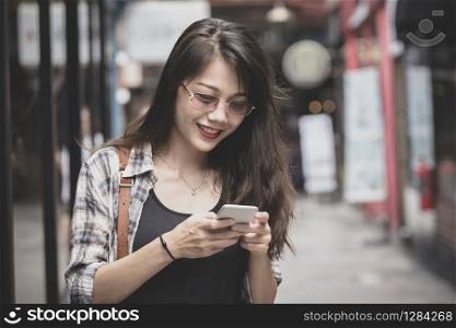 beautiful youger woman reading message on smart phone with smiling face