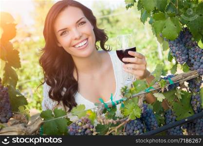 Beautiful Young Adult Woman Enjoying Glass of Wine Tasting In The Vineyard.