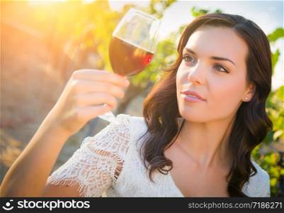 Beautiful Young Adult Woman Enjoying Glass of Wine Tasting In The Vineyard.