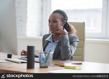 Beautiful young african american businesswoman working on computer at office