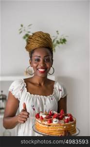 Beautiful young african woman cooking cake at kitchen