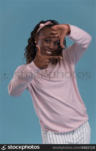 Beautiful young african woman framing photograph on blue background