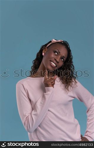Beautiful young african woman thinking and looking pensive on blue background