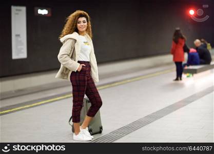 Beautiful young arabic female tourist waiting her train in a subway station. Arab girl in casual clothes.