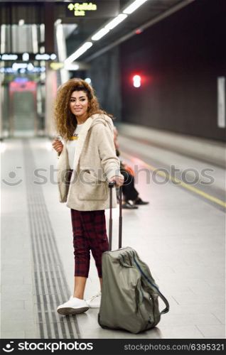 Beautiful young arabic woman waiting her train in a subway station. Arab girl in casual clothes.