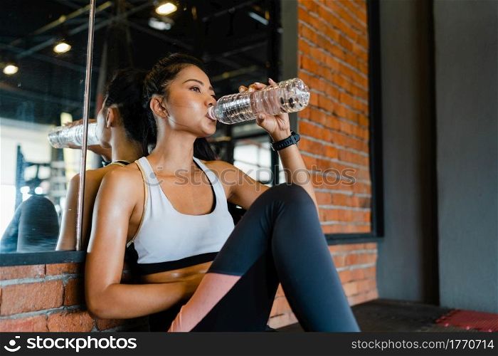 Beautiful young Asia lady exercise drinking water after fat burning workout in fitness class. Athlete with six pack, Sportswoman recreational activity, functional training, healthy lifestyle concept.
