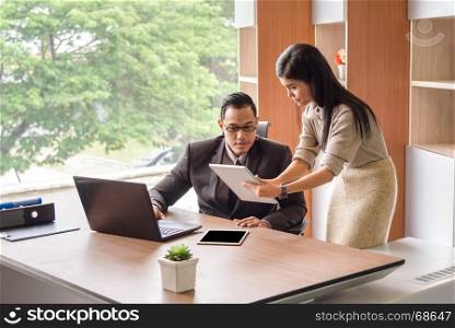 beautiful young asian business woman and man look at tablet for business project