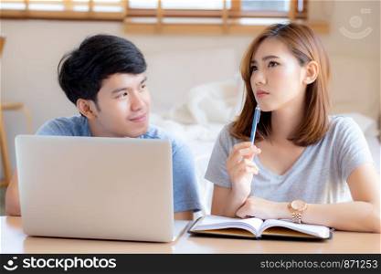 Beautiful young asian couple calculate expenses finance with laptop and planning together, woman writing notebook or note budget household, lifestyle family and business concept.