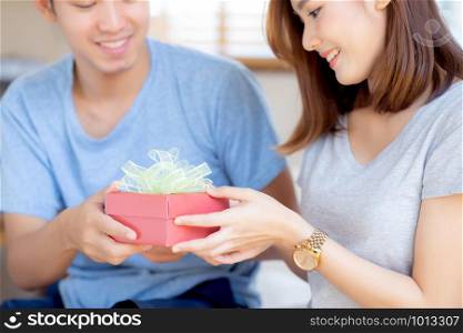 Beautiful young asian couple in love surprise gift box in bedroom at home, family anniversary with enjoy and romantic together wife and husband with relationship, Celebrating Valentine Day concept.