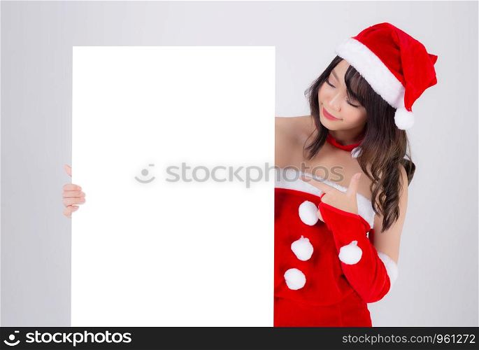 Beautiful young asian Santa woman holding blank board for xmas isolated on white background, asia girl show empty banner paper poster and pointing in Christmas holiday and new year for advertisement.