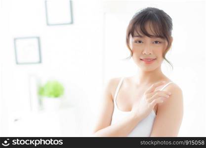 Beautiful young asian woman applying cream and treatment for skin care touch on shoulder, asia girl with lotion spa and moisturizing for health and wellness body part, lifestyle and beauty cosmetic concept.