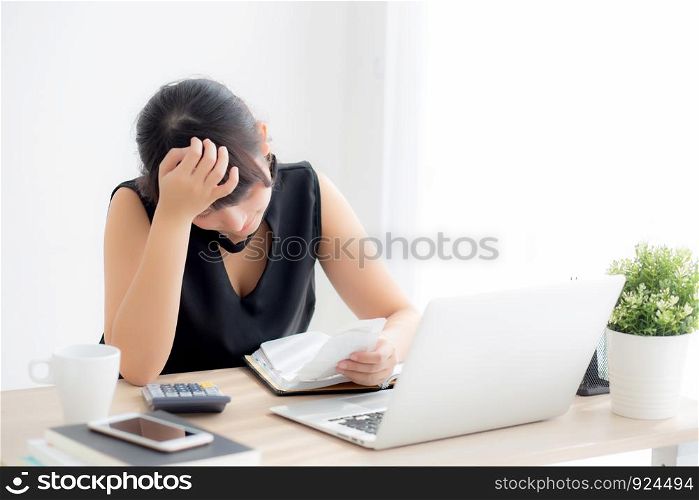 Beautiful young asian woman calculating expenses household and writing notebook on desk, girl checking bill and stress and note, female worry debt and tax, finance and business concept.