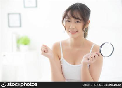 Beautiful young asian woman happy with magnifying skin of acne, beauty asia girl smiling check skincare of face, female analyzing trouble, cosmetic and makeup, health care and wellness concept.