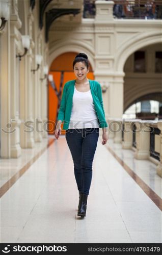Beautiful young asian woman in green blouse walking in the shop