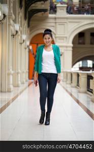 Beautiful young asian woman in green blouse walking in the shop