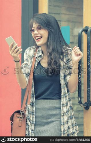 beautiful young asian woman looking to smart phone with happiness emotion