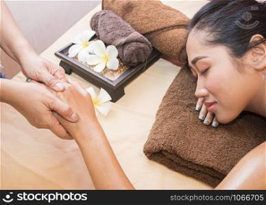 Beautiful young asian woman relaxing with hand massage at beauty spa. Close-up