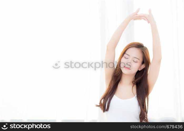 Beautiful young asian woman stretch and relax in bed after wake up morning at bedroom, new day and resting for wellness, lifestyle concept.