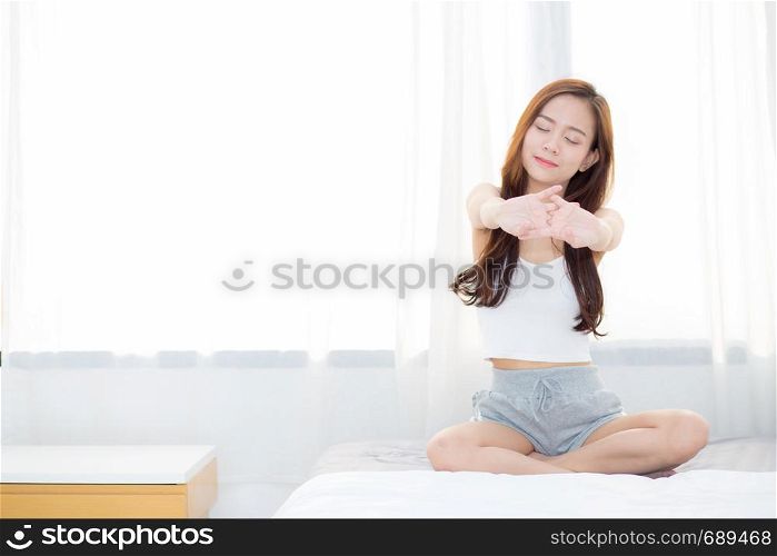 Beautiful young asian woman stretch and relax in bed after wake up morning at bedroom, new day and resting for wellness, lifestyle concept.
