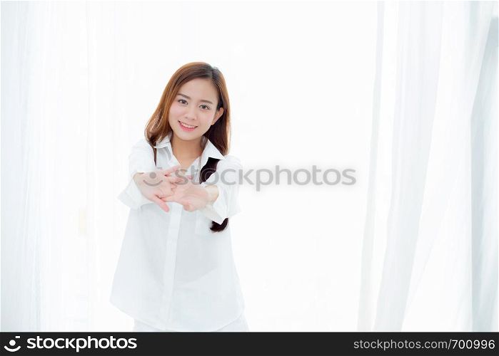 Beautiful young asian woman stretch and relax standing in bed after wake up morning at bedroom, new day and resting for wellness, lifestyle concept.