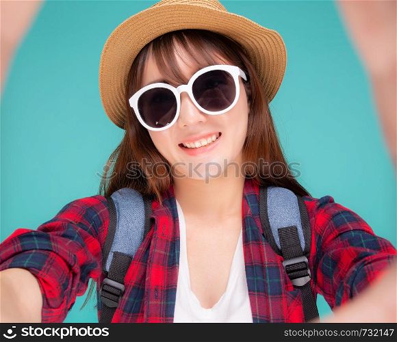 Beautiful young asian woman taking selfie with camera for relax in vacation isolated on blue background, asia girl wear clothes casual travel summer fashion excited, tourist and journey concept.