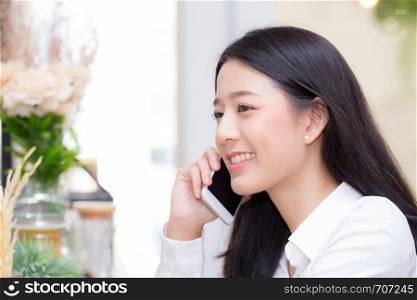 Beautiful young asian woman talking phone and smile in the coffee shop, businesswoman sitting in cafe free time, freelancer female calling telephone, communication concept.
