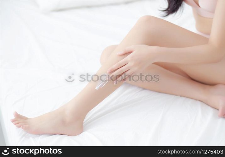 Beautiful young asian woman touch skin leg smooth with cream and lotion for hydration and smooth, girl applying body care and cosmetic for silky and soft, beauty perfect with wellness, health and care.