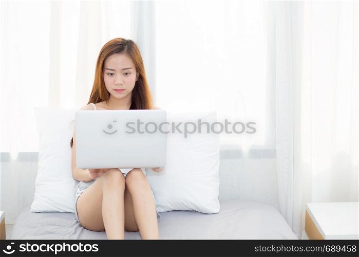 Beautiful young asian woman using laptop for leisure on bedroom, girl working online with notebook freelance, business concept.
