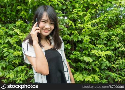 Beautiful young asian woman who talks on the telephone