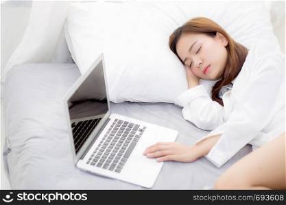 Beautiful young asian woman with laptop lying down in bedroom, girl tired sleep with computer notebook, resting and healthcare concept.