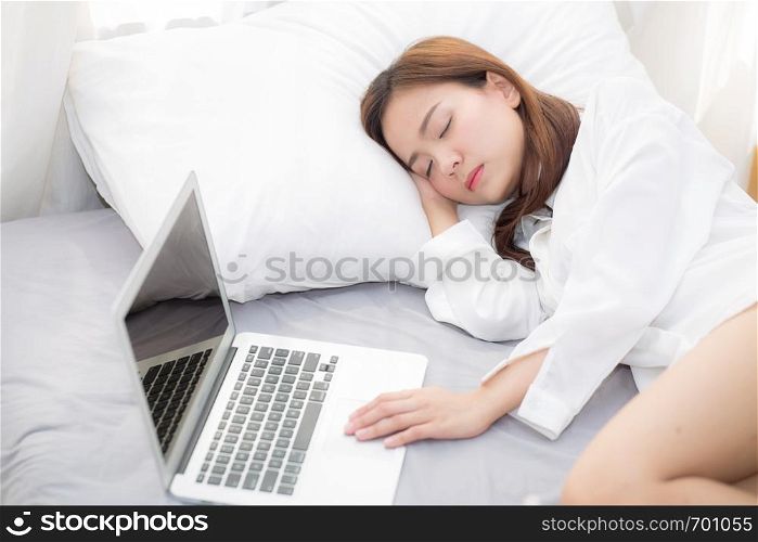 Beautiful young asian woman with laptop lying down in bedroom, girl tired sleep with computer notebook, resting and healthcare concept.