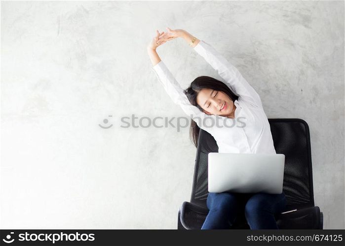Beautiful young asian woman with laptop stretch and exercise relax after work success, modern office with copy space, freelance business concept.