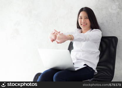 Beautiful young asian woman with laptop stretch and exercise relax after work success, modern office with copy space, freelance business concept.
