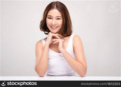 Beautiful Young Asian Woman with short hair Holding Hands smile feeling so happy and cheerful with healthy Clean and Fresh skin,isolated on gray background,Beauty Cosmetics Concept