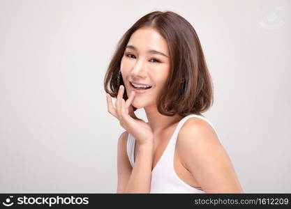 Beautiful Young Asian Woman with short hair Looking While Touching Chin feeling so happy and cheerful with healthy Clean and Fresh skin,isolated on white background,Beauty Cosmetics Concept