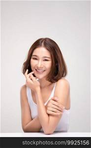 Beautiful Young Asian Woman with short hairs Touching Shoulder feeling so happy and cheerful with healthy Clean and Fresh skin,isolated on gray background,Beauty Cosmetology Concept