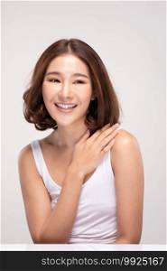 Beautiful Young Asian Woman with short hairs Touching Shoulder feeling so happy and cheerful with healthy Clean and Fresh skin,isolated on gray background,Beauty Cosmetology Concept