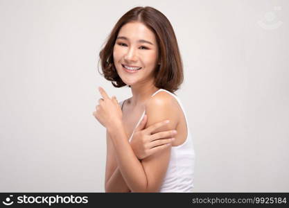 Beautiful Young Asian Woman with short hairs Touching Shoulder feeling so happy and cheerful with healthy Clean and Fresh skin,isolated on gray background,Beauty Cosmetology Concept