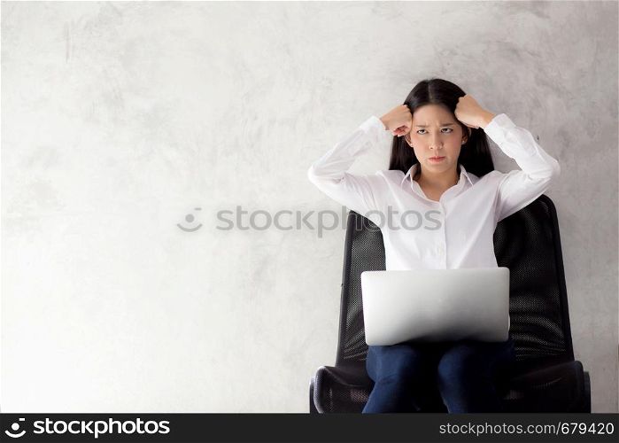 Beautiful young asian woman working and thinking with problem to stress and unhappy, businesswoman with laptop computer on cement background with emotion, freelance business concept.