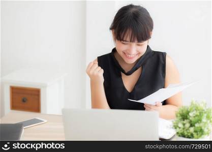 Beautiful young asian woman working laptop computer at office, businesswoman looking graph diagram analysis statistic data with excited and success, girl using notebook, business concept.