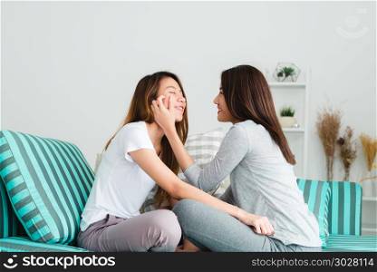 Beautiful young asian women LGBT lesbian happy couple sitting on. Beautiful young asian women LGBT lesbian happy couple sitting on sofa hugging and smiling together in living room at home. LGBT lesbian couple together indoors concept. Spending nice time at home.