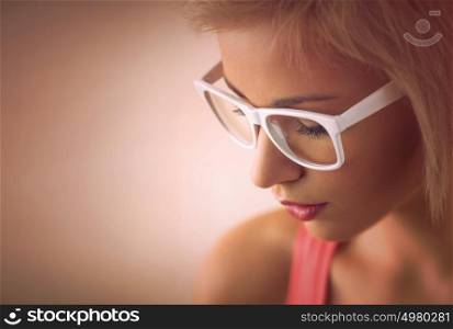 Beautiful young blond girl with short hair wearing glasses in pink style