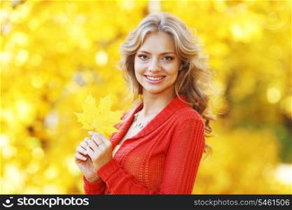 Beautiful young blond woman posing in autumn park