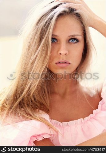 Beautiful young blonde girl in pink dress