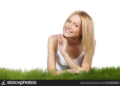 Beautiful young blonde smiling woman lying on grass, isolated on white background