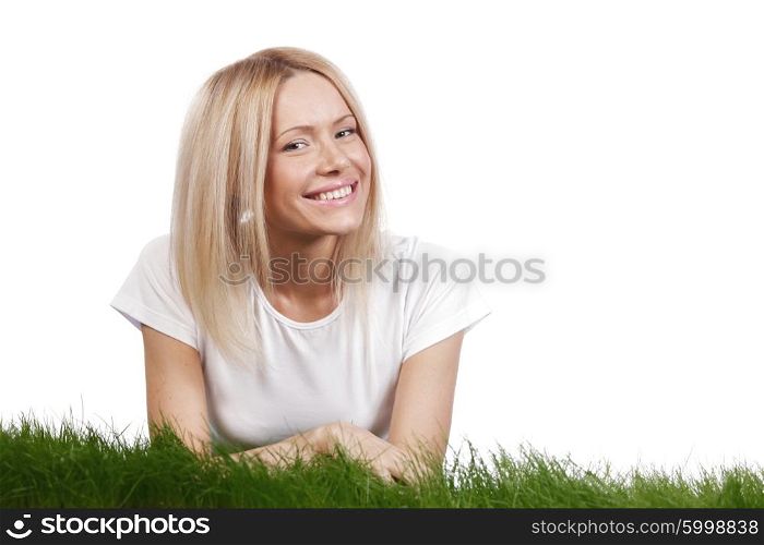 Beautiful young blonde smiling woman lying on grass, isolated on white background