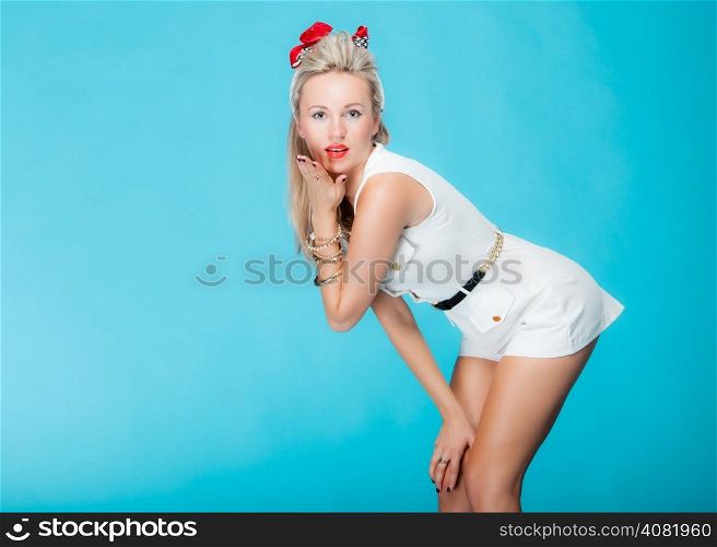 Beautiful young blonde woman in pin-up retro style vintage styling on vivid blue background