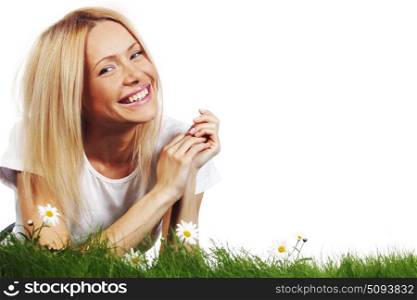 Beautiful young blonde woman lying on grass with chamomile flowers, isolated on white background. Woman on grass with flowers